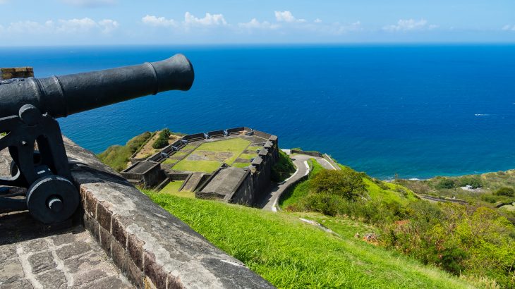 Old cannon overlooking fortress on hill overlooking the ocean in St. Kitts