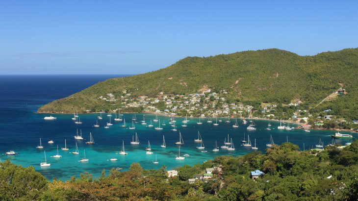 Green mountains overlooking a harbour with sailboats in St. Vincent