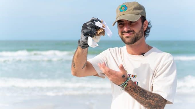 Caulin Donaldson holding up trash at beach cleanup in florida