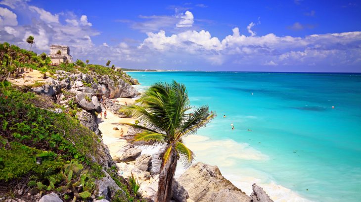 Tulum ruins over beach with palm. Tulum temple overlooking the beach. There is so much to see here and some fantastic views