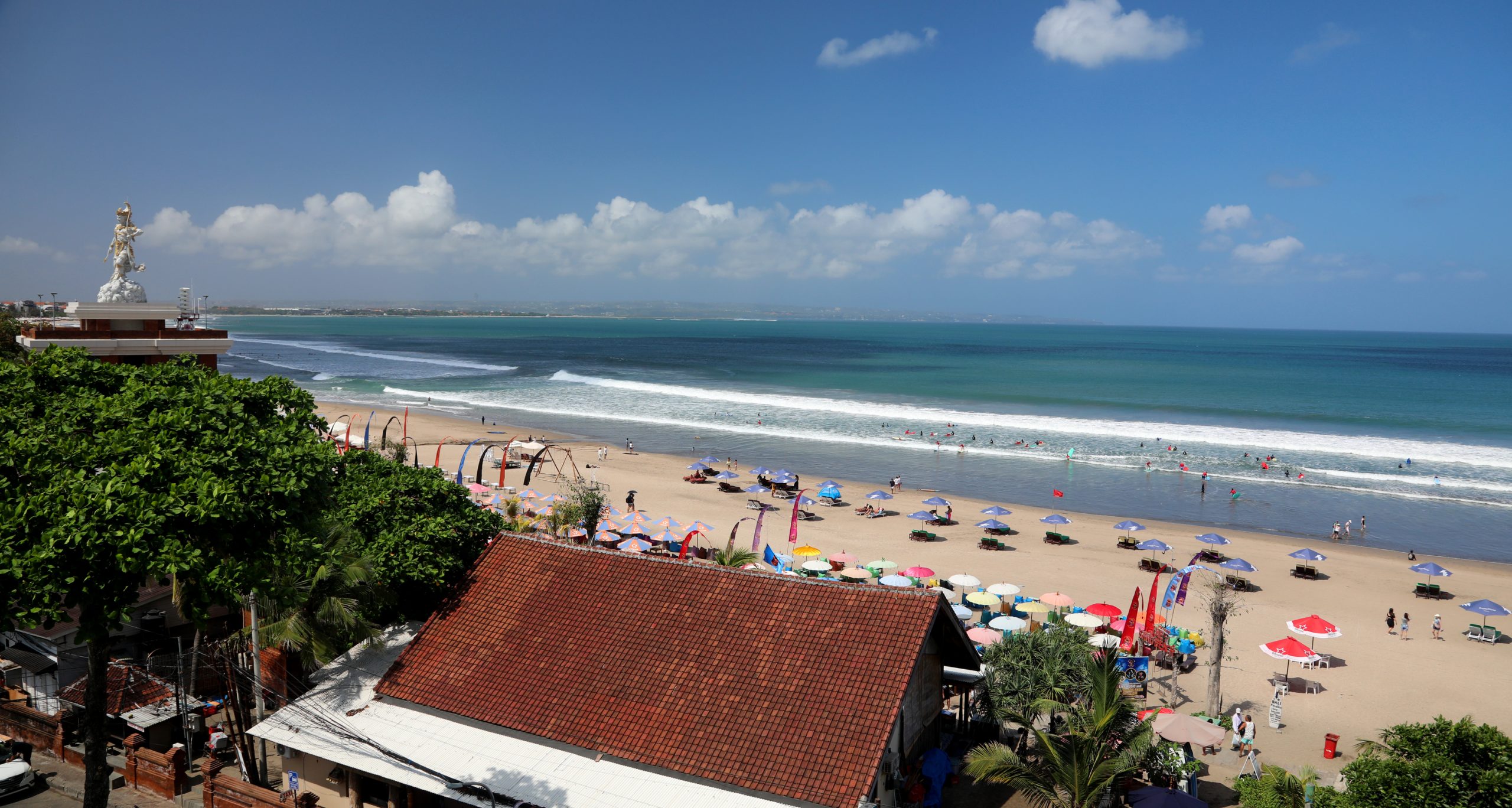 colorful umbrellas and restaurants at seminyak beach bali on the golden sands in the sun