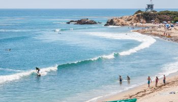 Surfers, swimmers and sunbathers enjoying a summer day in southern California.